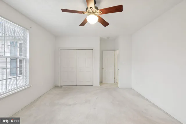 an empty room with chandelier fan
