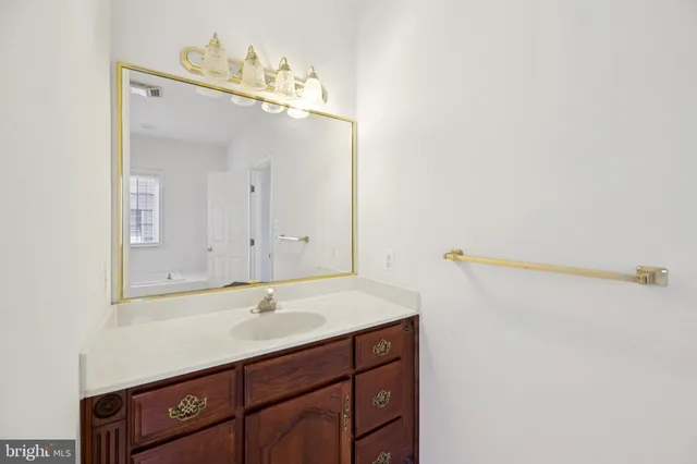 a bathroom with a sink vanity and mirror