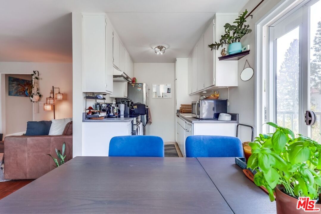 3734 South Canfield Avenue, Unit 331 Los Angeles, CA 90034 - Photo 18 of 45 a living room with furniture a chandelier and a large window