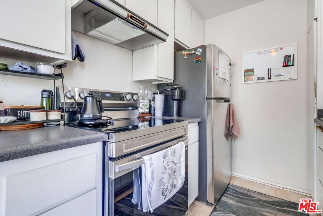 3734 South Canfield Avenue, Unit 331 Los Angeles, CA 90034 - Photo 23 of 45 a kitchen with stainless steel appliances granite countertop a refrigerator a stove and a sink