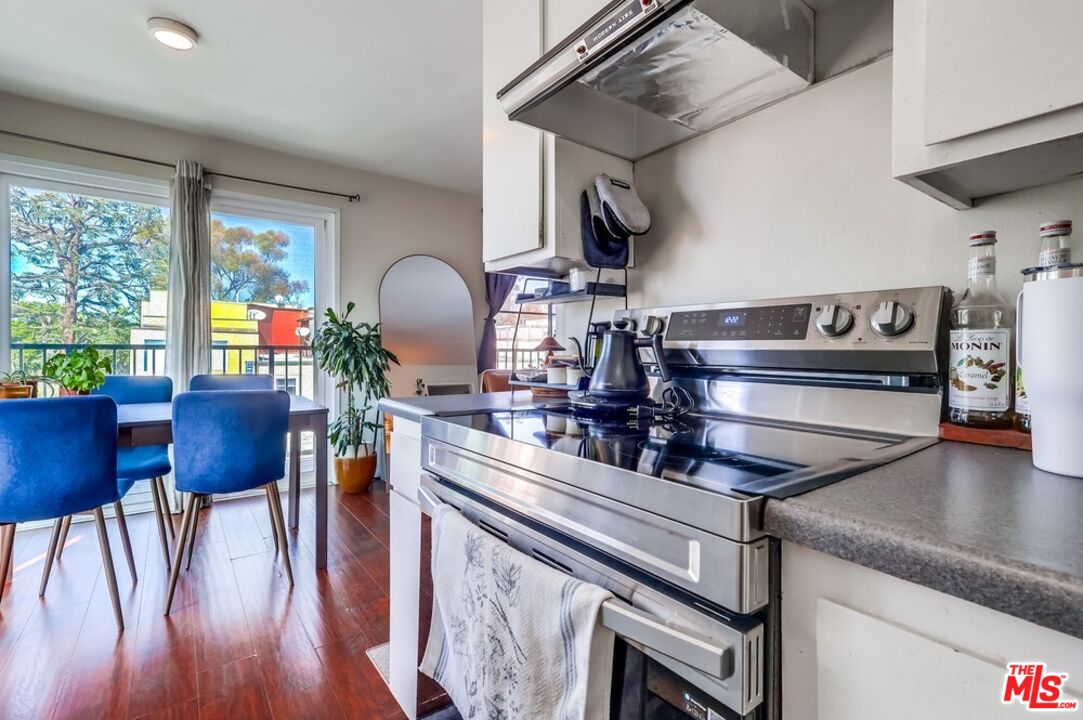 3734 South Canfield Avenue, Unit 331 Los Angeles, CA 90034 - Photo 25 of 45 a kitchen with stainless steel appliances granite countertop a stove a sink and a dining table