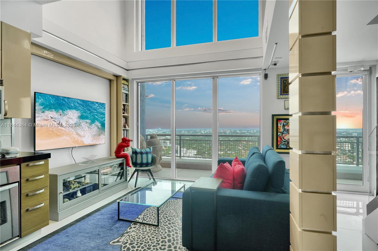 60 Southwest 13th Street, Unit 4411 Miami, FL 33130 - Photo 35 of 38 a living room with furniture a flat screen tv and a floor to ceiling window