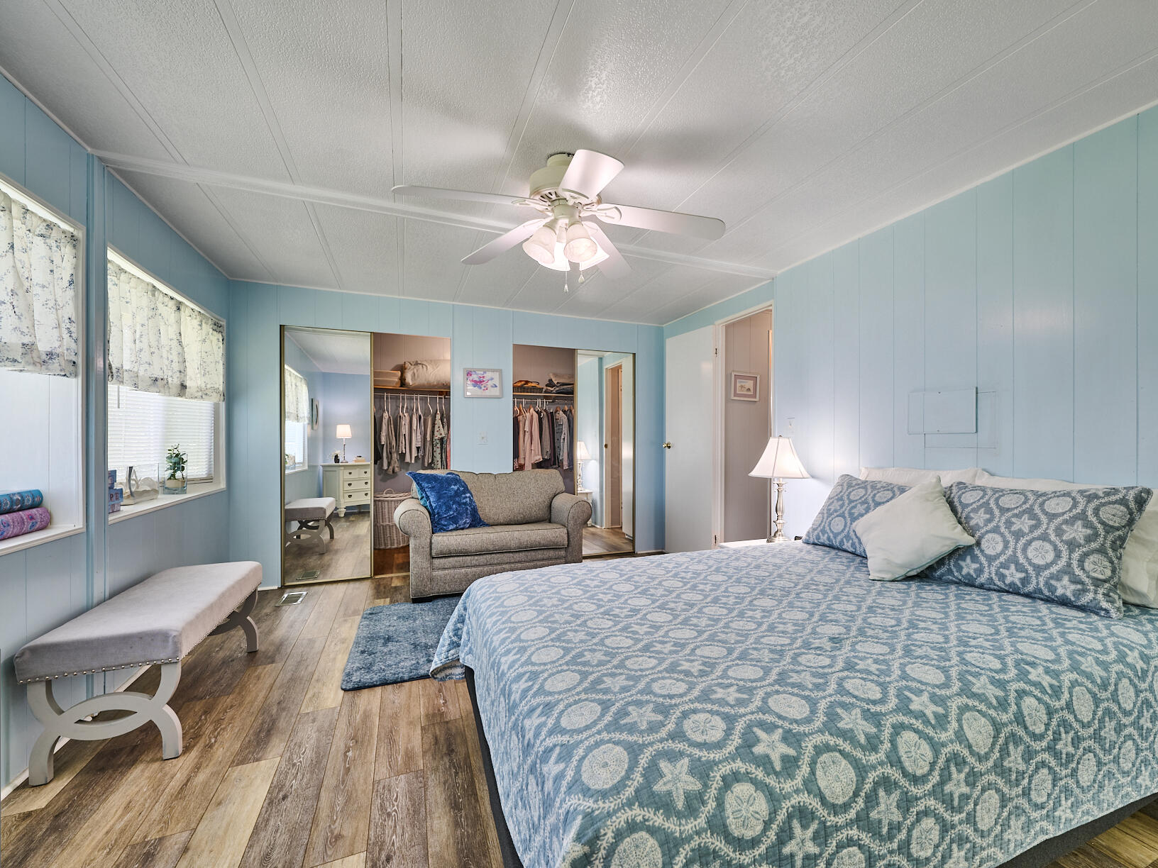 6977 Southeast Delegate Street Hobe Sound, FL 33455 - Photo 30 of 60 a bedroom with a large bed and a chandelier