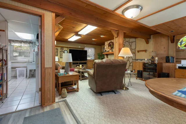 a living room with furniture a flat screen tv and a floor to ceiling window