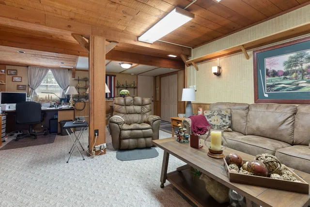 a living room with furniture and a dining table with wooden floor