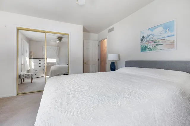 a bedroom with a bed and a large mirror