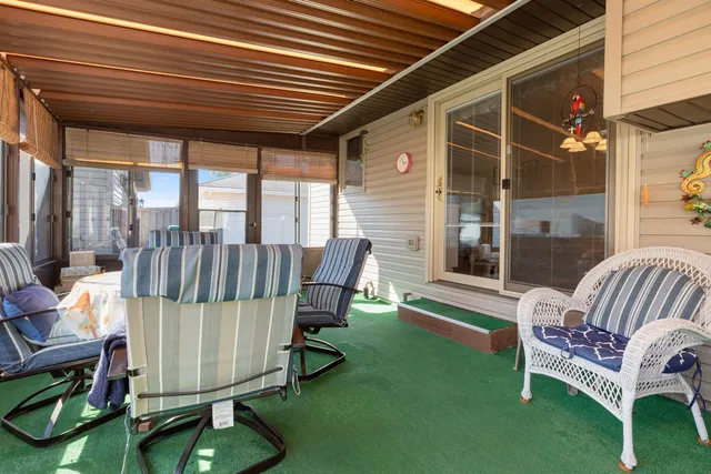 a view of a porch with furniture and a yard