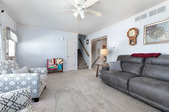 a living room with furniture and a ceiling fan