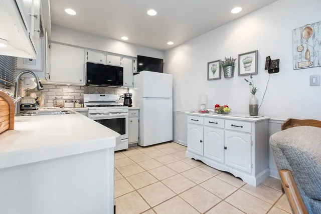 a kitchen with white cabinets and stainless steel appliances