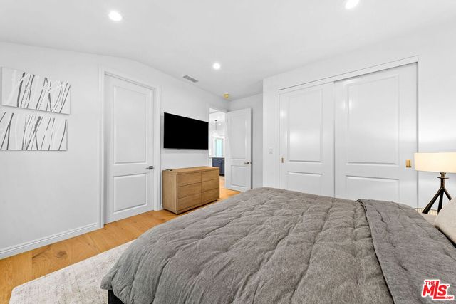 a bedroom with a bed and a flat screen tv