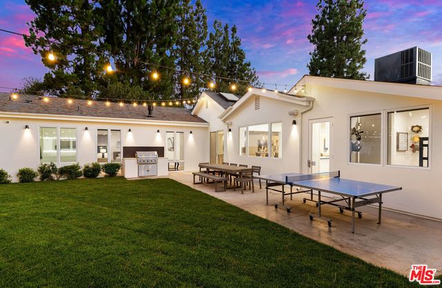 a view of a house with a backyard porch and sitting area