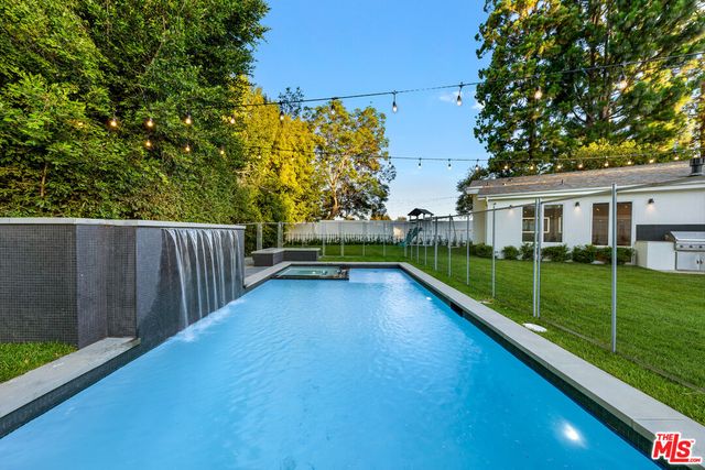 a view of an house with backyard and a tree