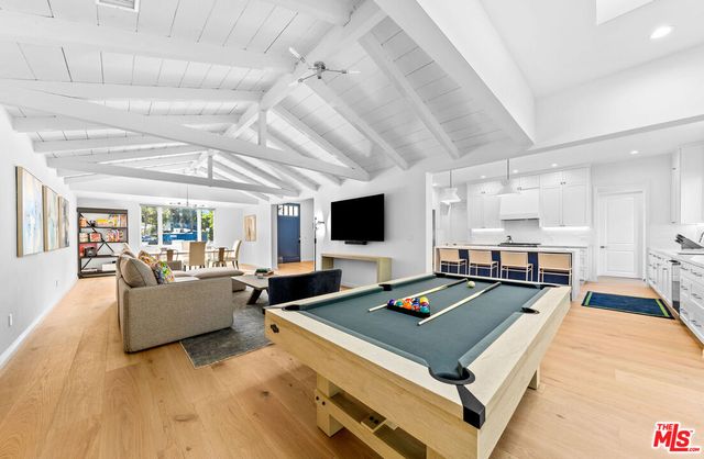 a living room with furniture pool table and a flat screen tv