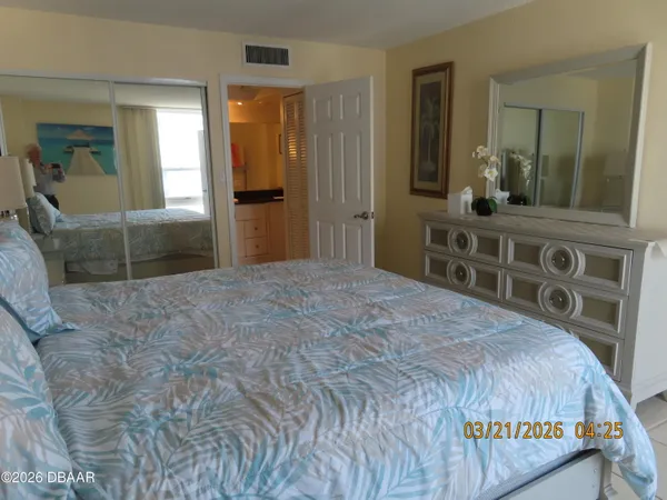 a bedroom with a bed and a mirror on dresser