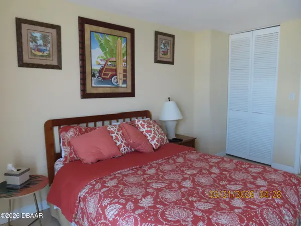 a bedroom with a bed and painting on the wall