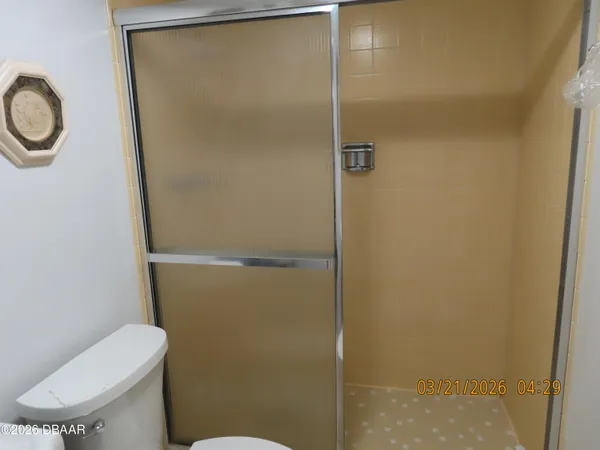 a white toilet sitting next to a shower