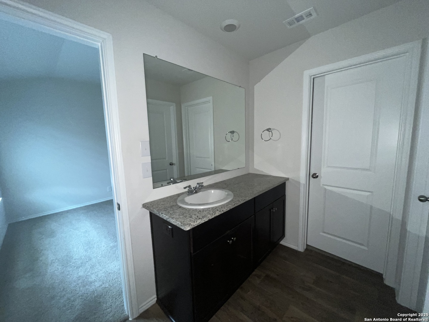 324 Middle Green Loop Floresville, TX 78114 - Photo 16 of 30 a bathroom with a granite countertop sink and a mirror