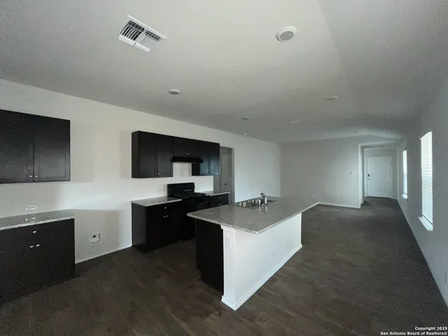 a kitchen with sink stove and refrigerator