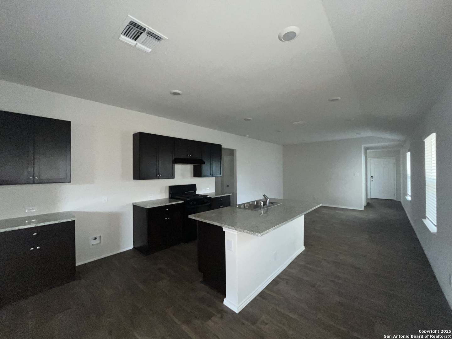 324 Middle Green Loop Floresville, TX 78114 - Photo 7 of 30 a kitchen with sink stove and refrigerator