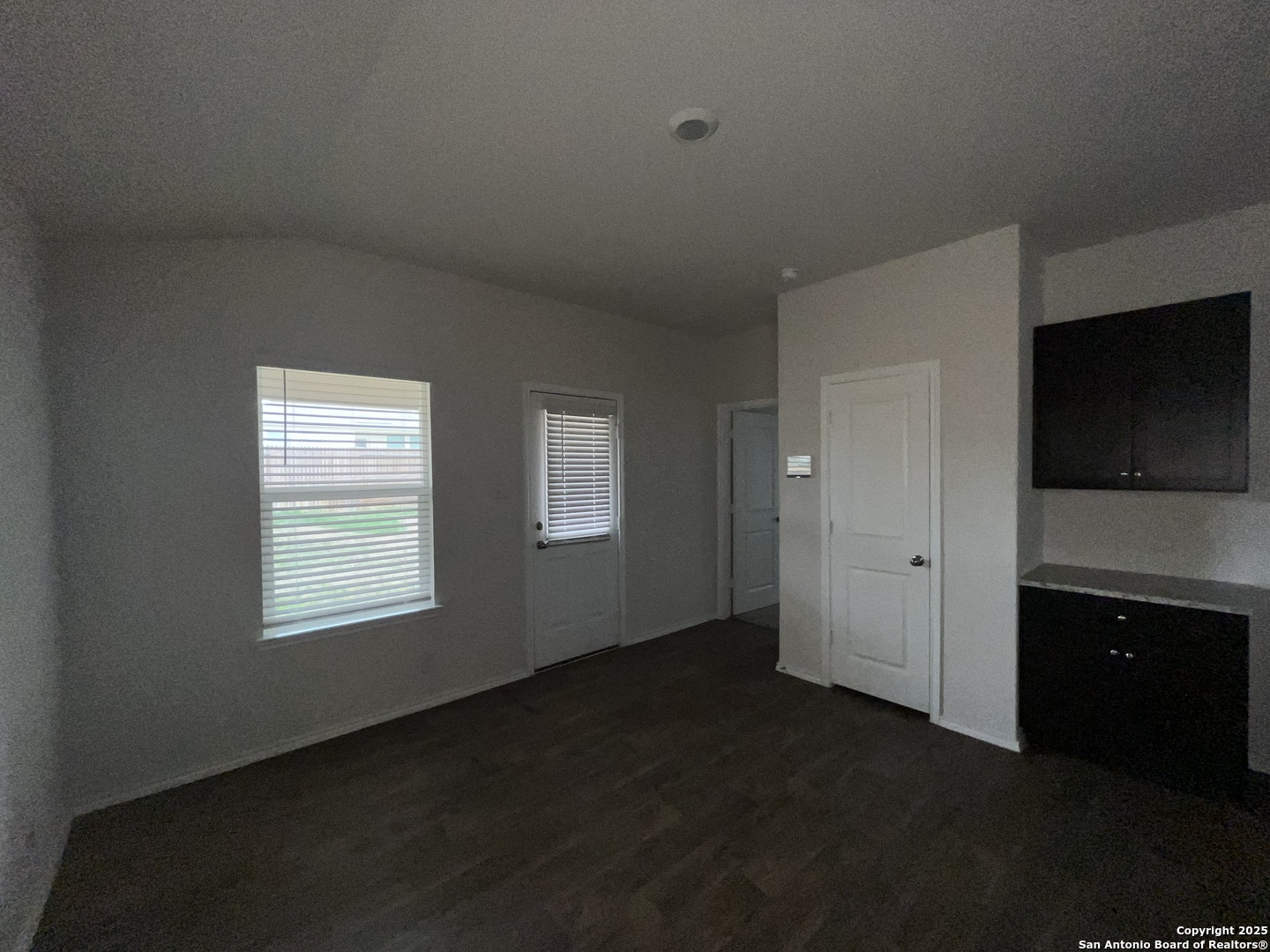 324 Middle Green Loop Floresville, TX 78114 - Photo 8 of 30 a view of an empty room with a kitchen and a window