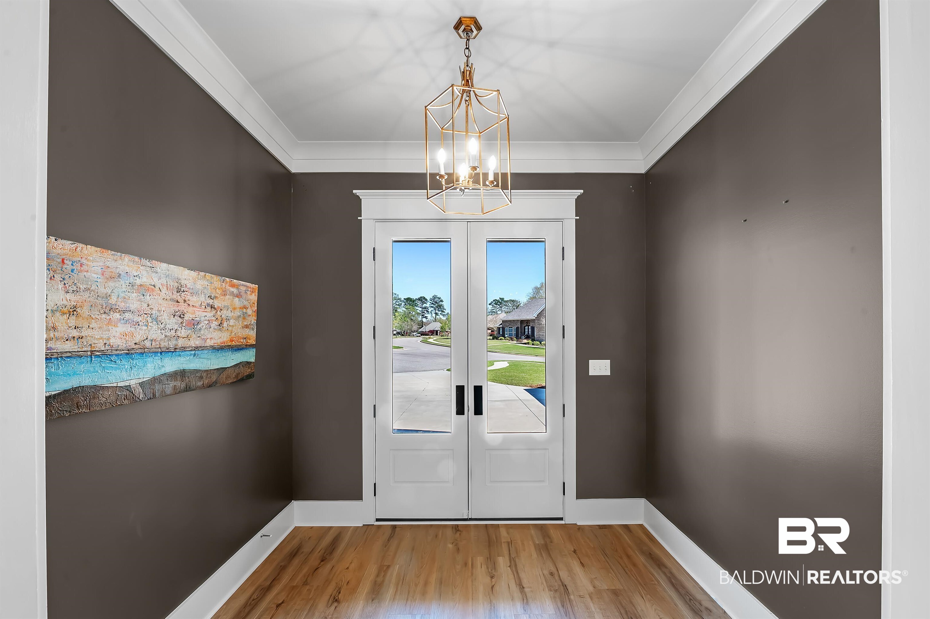 27888 Oakachoy Loop Daphne, AL 36526 - Photo 43 of 65 Doorway to outside with french doors, an inviting chandelier, ornamental molding, baseboards, and wood finished floors