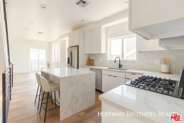 a kitchen with a sink a stove and chairs