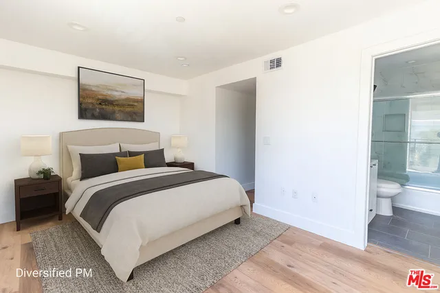 a bedroom with a bed and a painting on the wall