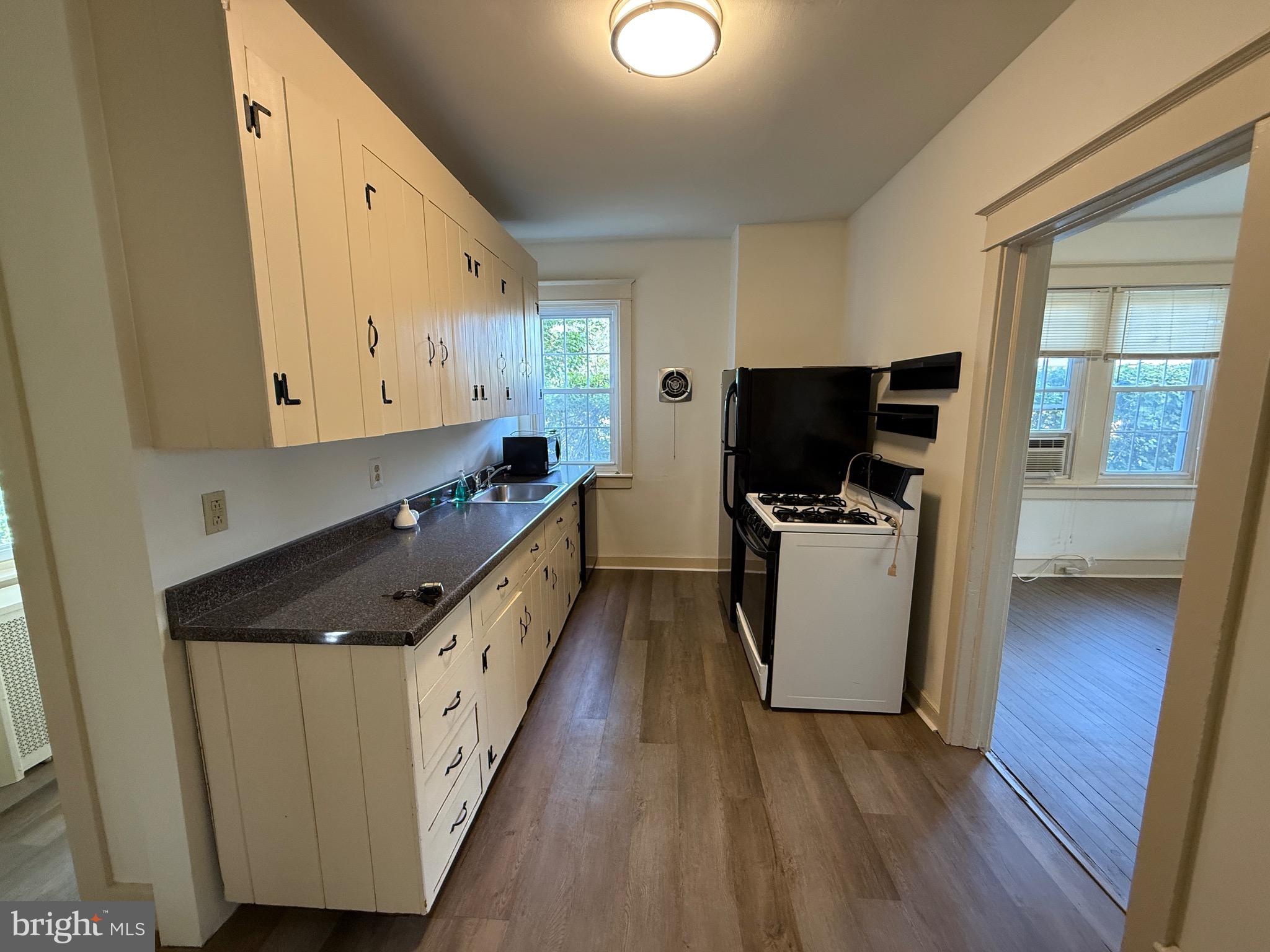305 West Wayne Avenue, Unit 1 Wayne, PA 19087 - Photo 6 of 9 a kitchen with granite countertop a sink and a stove top oven