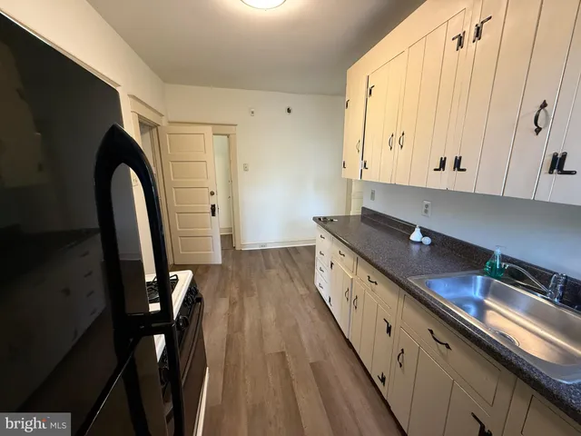 a view of a kitchen with stainless steel appliances granite countertop a stove a sink dishwasher and cabinets with wooden floor
