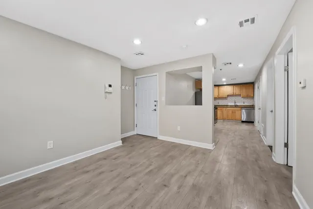 a view of a big room with wooden floor and windows
