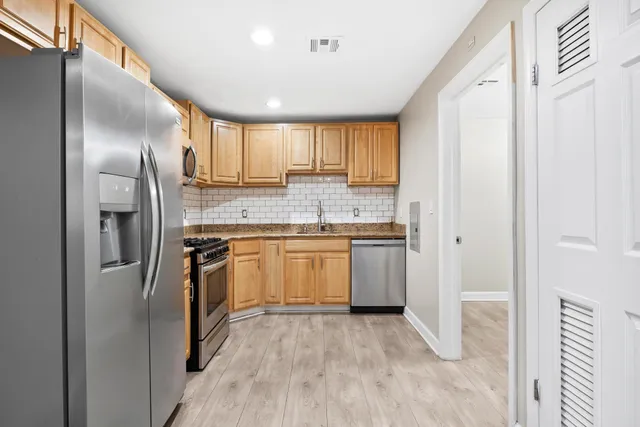 a kitchen with a refrigerator sink and cabinets