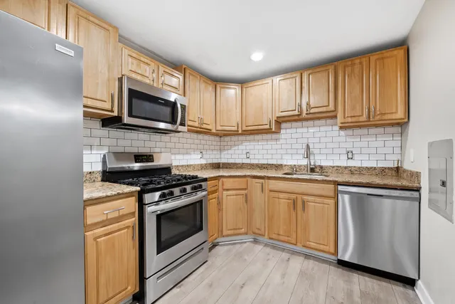 a kitchen with stainless steel appliances granite countertop a stove a sink and a microwave