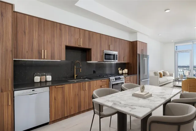 a kitchen with a stove a sink a microwave a dining table and chairs