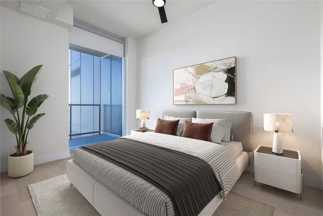 a bedroom with a large bed and a potted plant