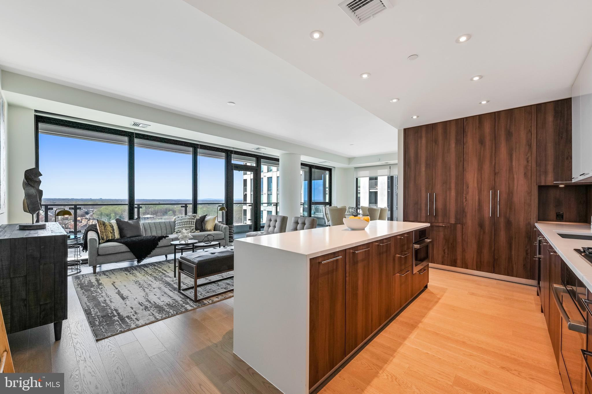 a living room with stainless steel appliances granite countertop furniture wooden floor and a view of kitchen