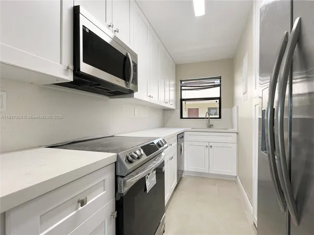 a kitchen with stainless steel appliances a stove microwave and refrigerator