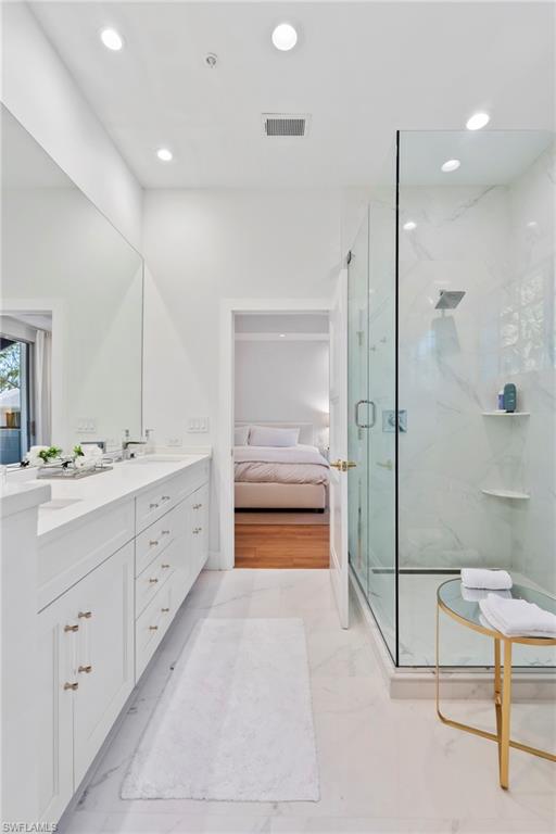 888 10th Street South, Unit 101 Naples, FL 34102 - Photo 18 of 31 a bathroom with a double vanity sink a toilet and shower