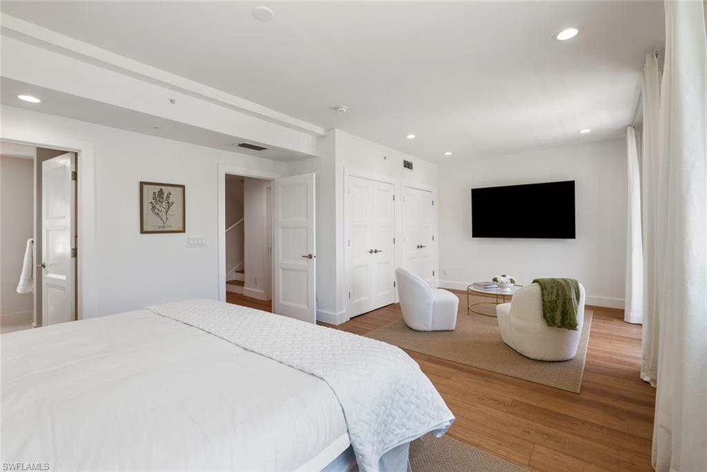 888 10th Street South, Unit 101 Naples, FL 34102 - Photo 19 of 31 a bedroom with a bed and flat tv