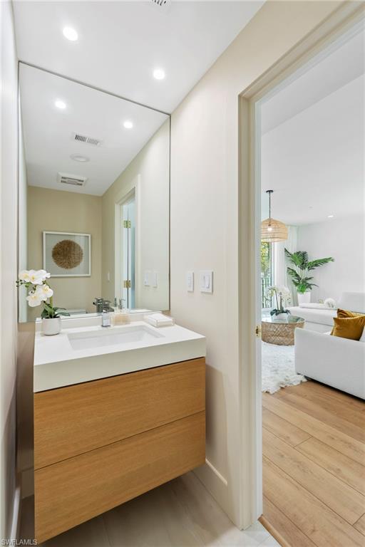 888 10th Street South, Unit 101 Naples, FL 34102 - Photo 23 of 31 a en suite bathroom with a sink mirror and tub