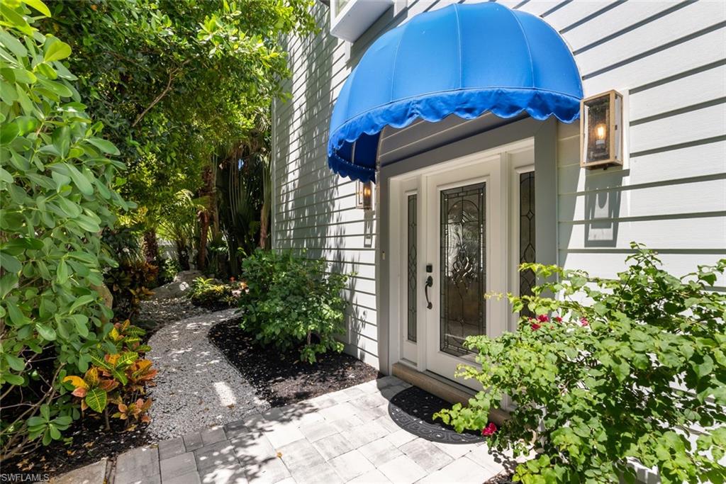 888 10th Street South, Unit 101 Naples, FL 34102 - Photo 3 of 31 a view of a house with a small yard