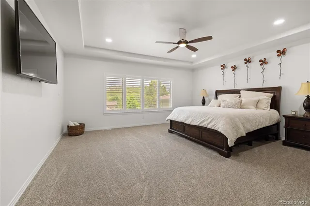 a spacious bedroom with a bed and a flat screen tv