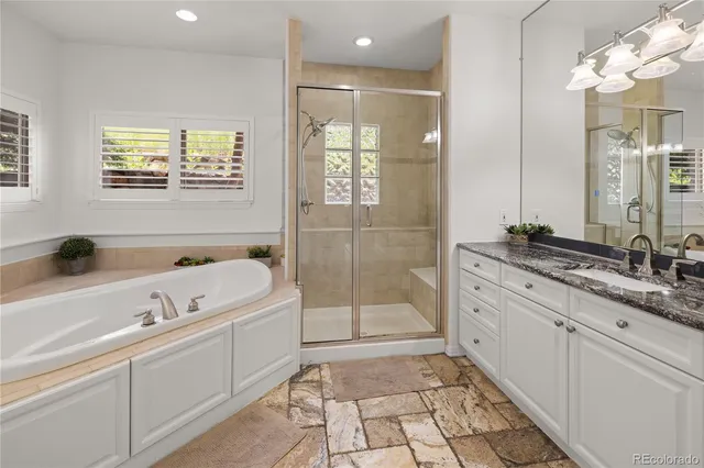 a bathroom with a tub a sink and mirror