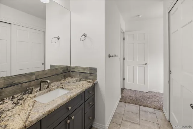 a bathroom with a granite countertop sink and a mirror