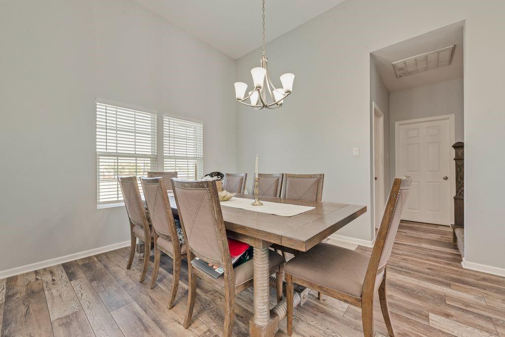 610 Ewing Road Ferris, TX 75125 - Photo 6 of 22 Vaulted ceilings, wood-finish flooring, and multiple windows with blinds
