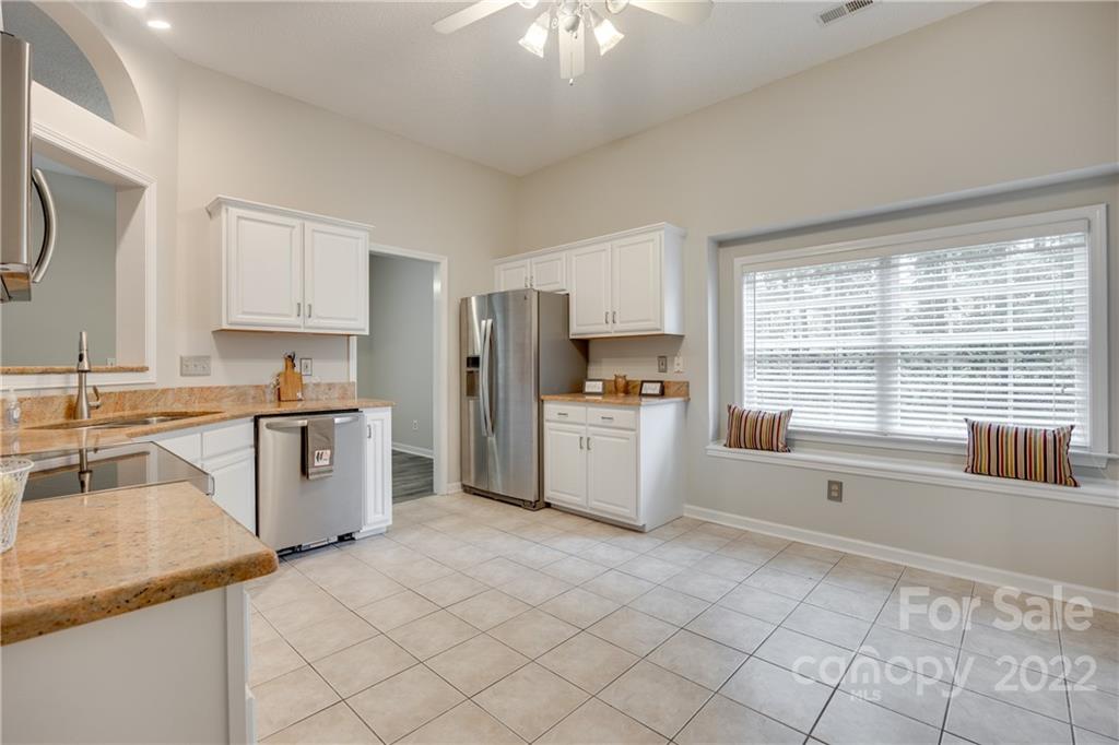 1307 Crown Ridge Drive Fort Mill, SC 29708 - Photo 11 of 24 a kitchen with granite countertop a refrigerator sink stove and cabinets
