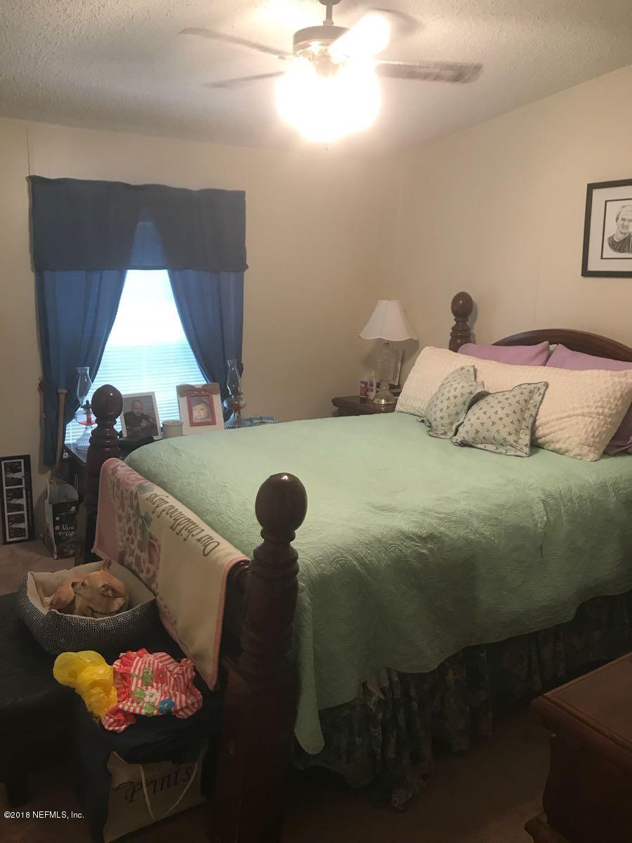 1609 Blair Road Jacksonville, FL 32221 - Photo 14 of 30 a bedroom with a bed and a chandelier