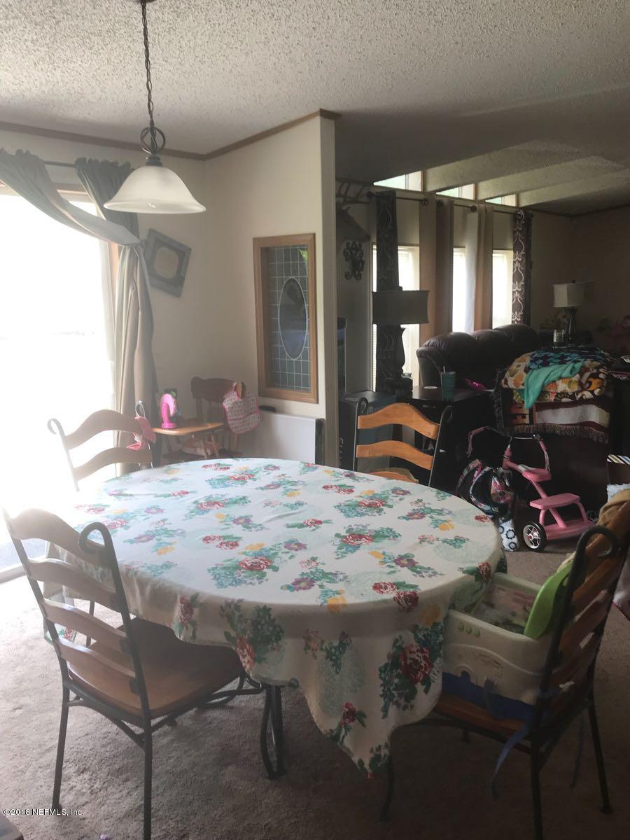 1609 Blair Road Jacksonville, FL 32221 - Photo 6 of 30 a dining table chairs and a chandelier