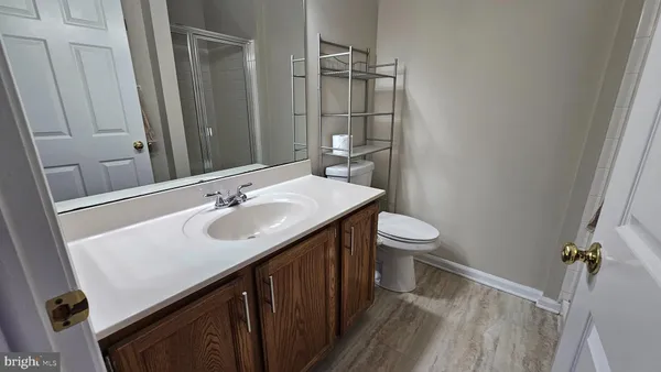 a bathroom with a sink a toilet a mirror and shower