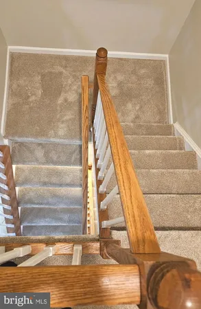 a view of staircase with white walls and railing