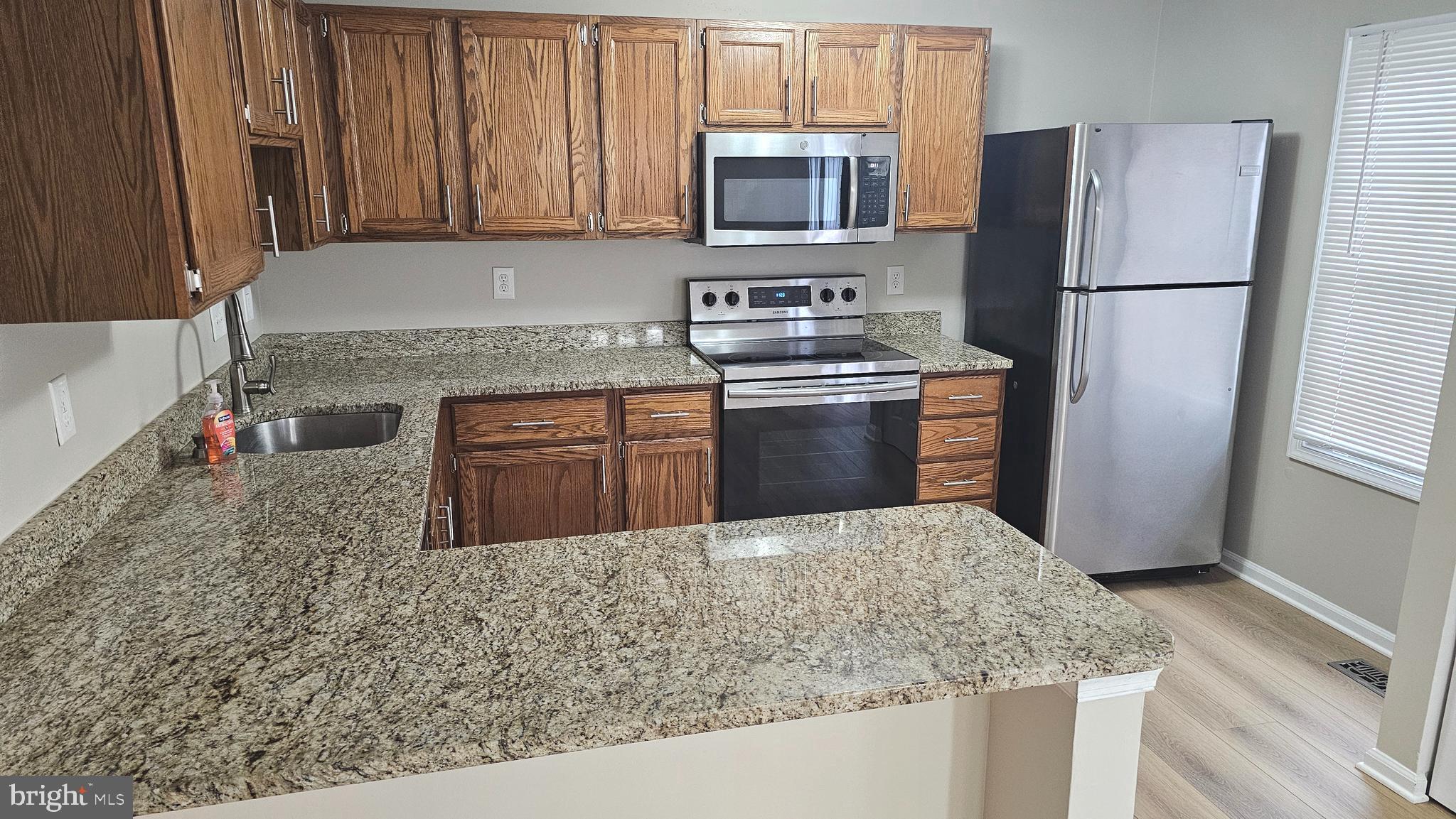 1196 Swanhill Court Chestnut Hill Cove, MD 21226 - Photo 6 of 32 a kitchen with stainless steel appliances granite countertop a refrigerator sink stove microwave and cabinets